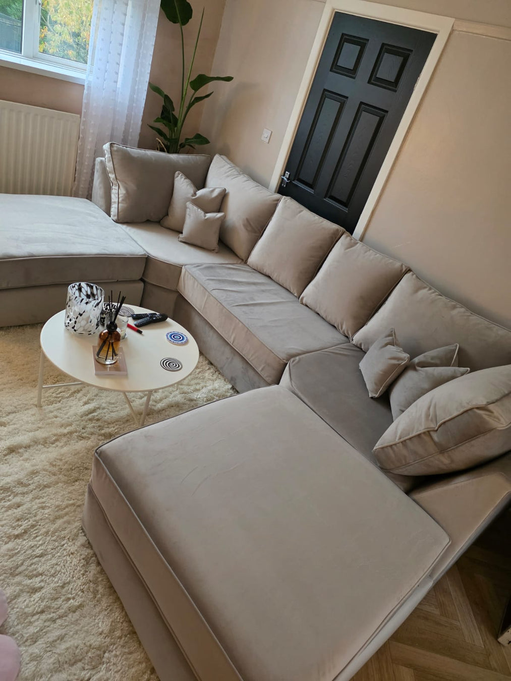 Imogen sectional sofa in a living room with a coffee table and decorative items.
